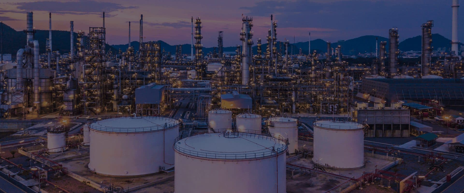 Natural gas processing plant and storage tanks at dusk