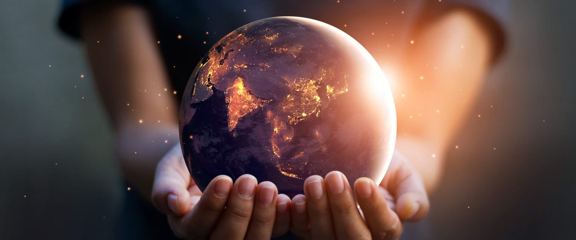 Hands holding a glowing globe at night, symbolising power trading